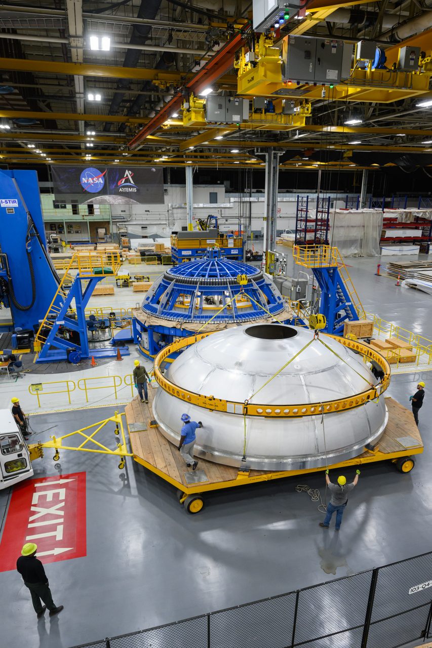 Technicians maneuver NASA's SLS rocket liquid oxygen tank dome inside Michoud Assembly Facility for welding assembly.
