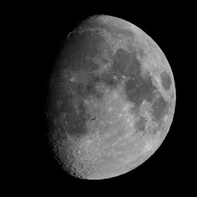 The International Space Station crossing in front of the moon during a lunar transit.