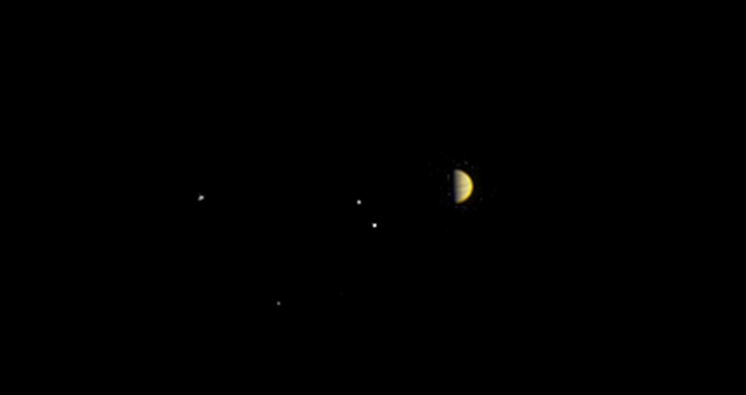NASA's Juno spacecraft approaching Jupiter with its four largest moons visible: Io, Europa, Ganymede, and Callisto.