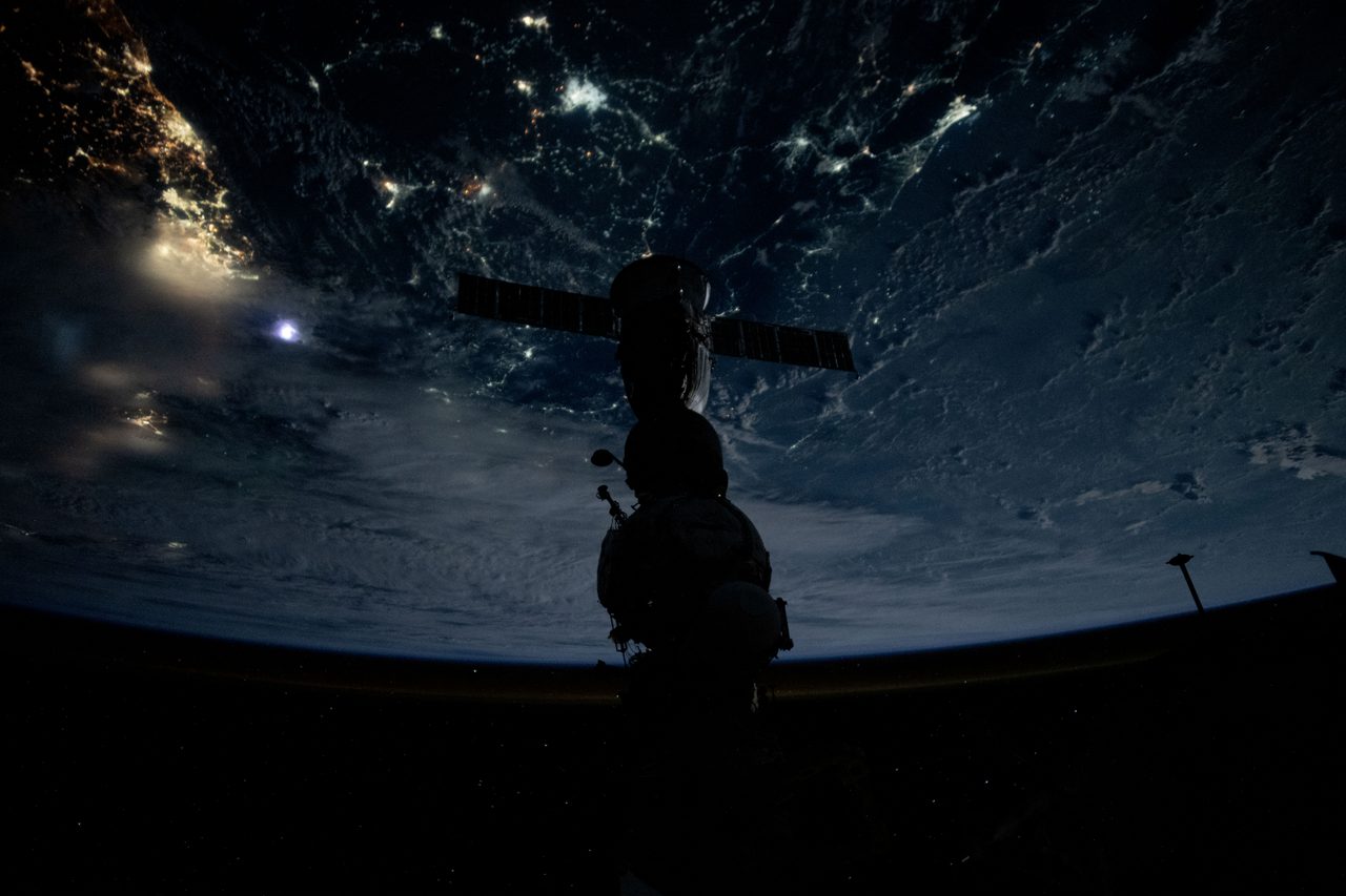 The Soyuz MS-25 crew ship docked to the Prichal module, silhouetted against Earth during a nighttime pass over Jakarta.