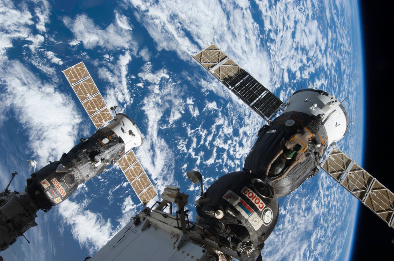 Russian Soyuz and Progress spacecrafts docked at International Space Station in space.