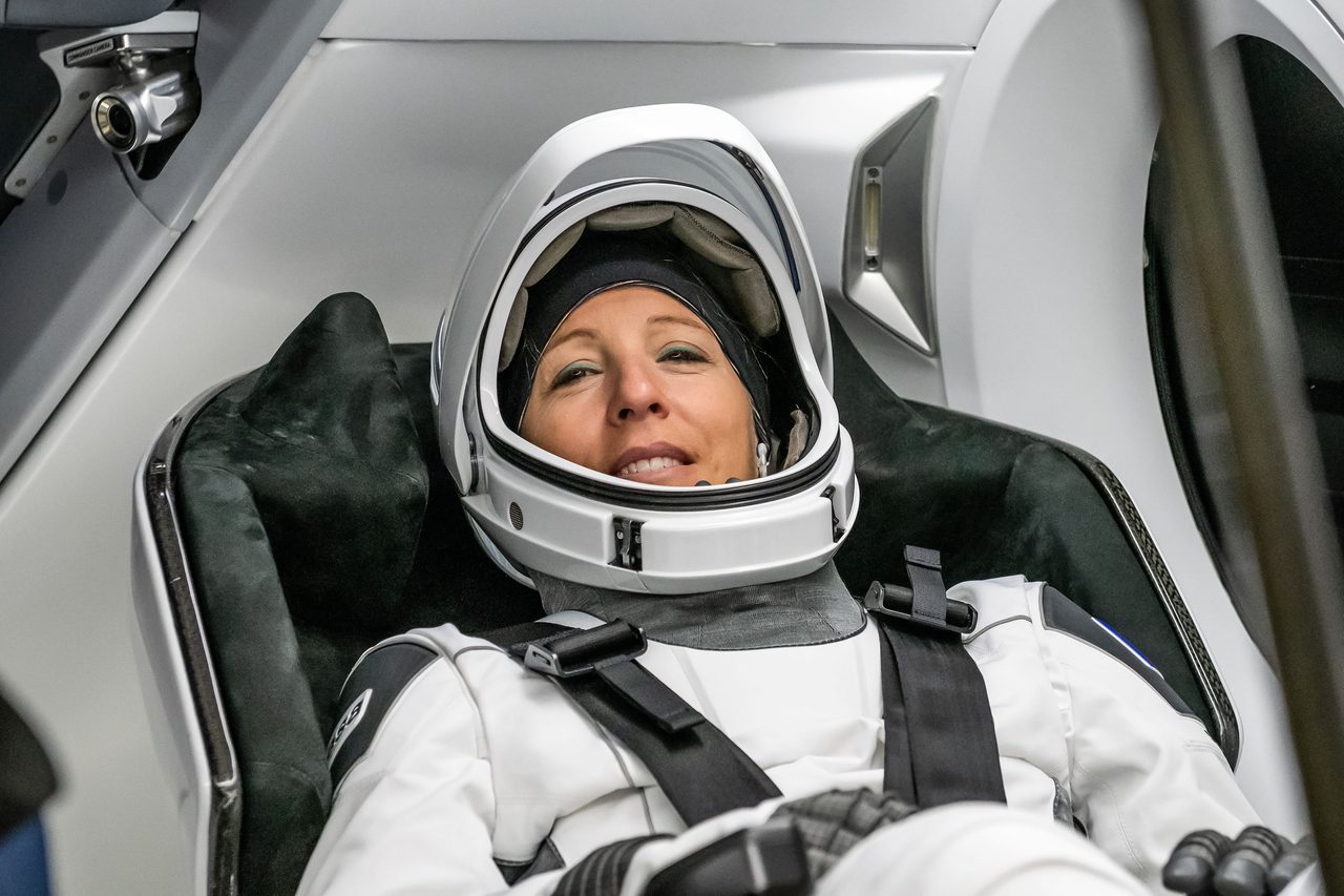 ESA astronaut Sophie Adenot in a pressure suit inside SpaceX Dragon spacecraft during training at Kennedy Space Center.