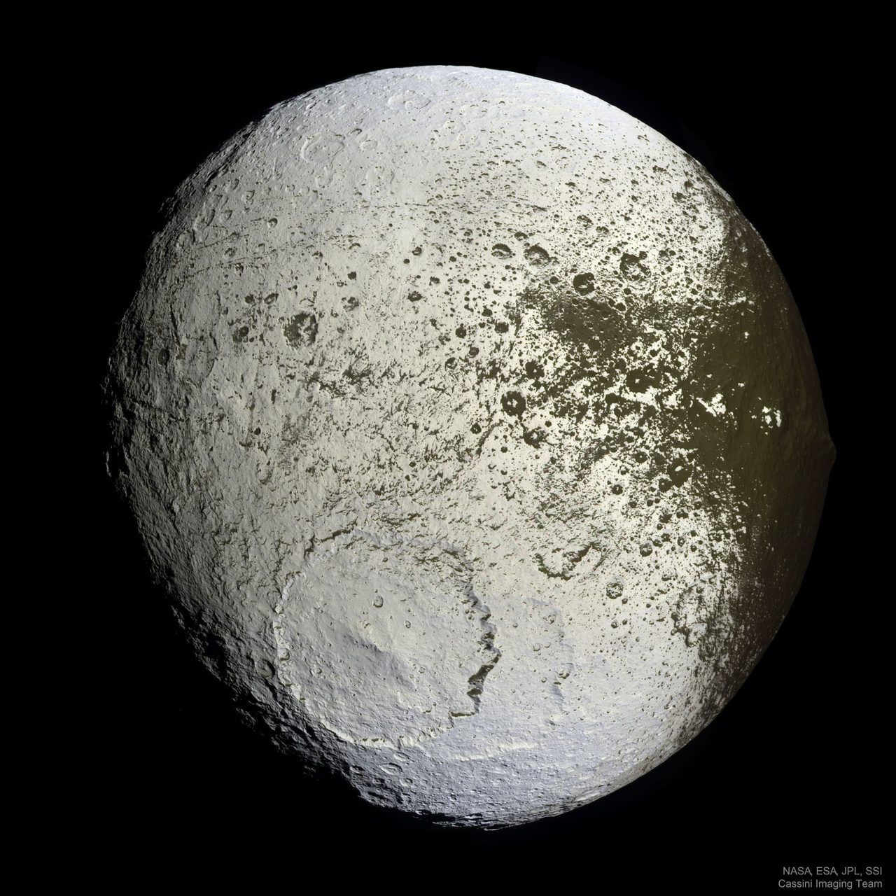 A detailed view of Saturn's moon Iapetus, showcasing its distinct two-tone surface with bright and dark regions.