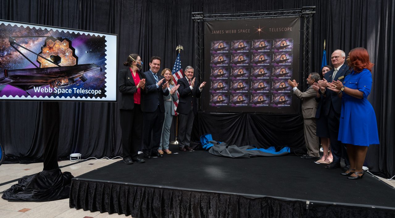 A group of people gathered at the JWST Stamp Issuance Ceremony, showcasing the new commemorative stamp.
