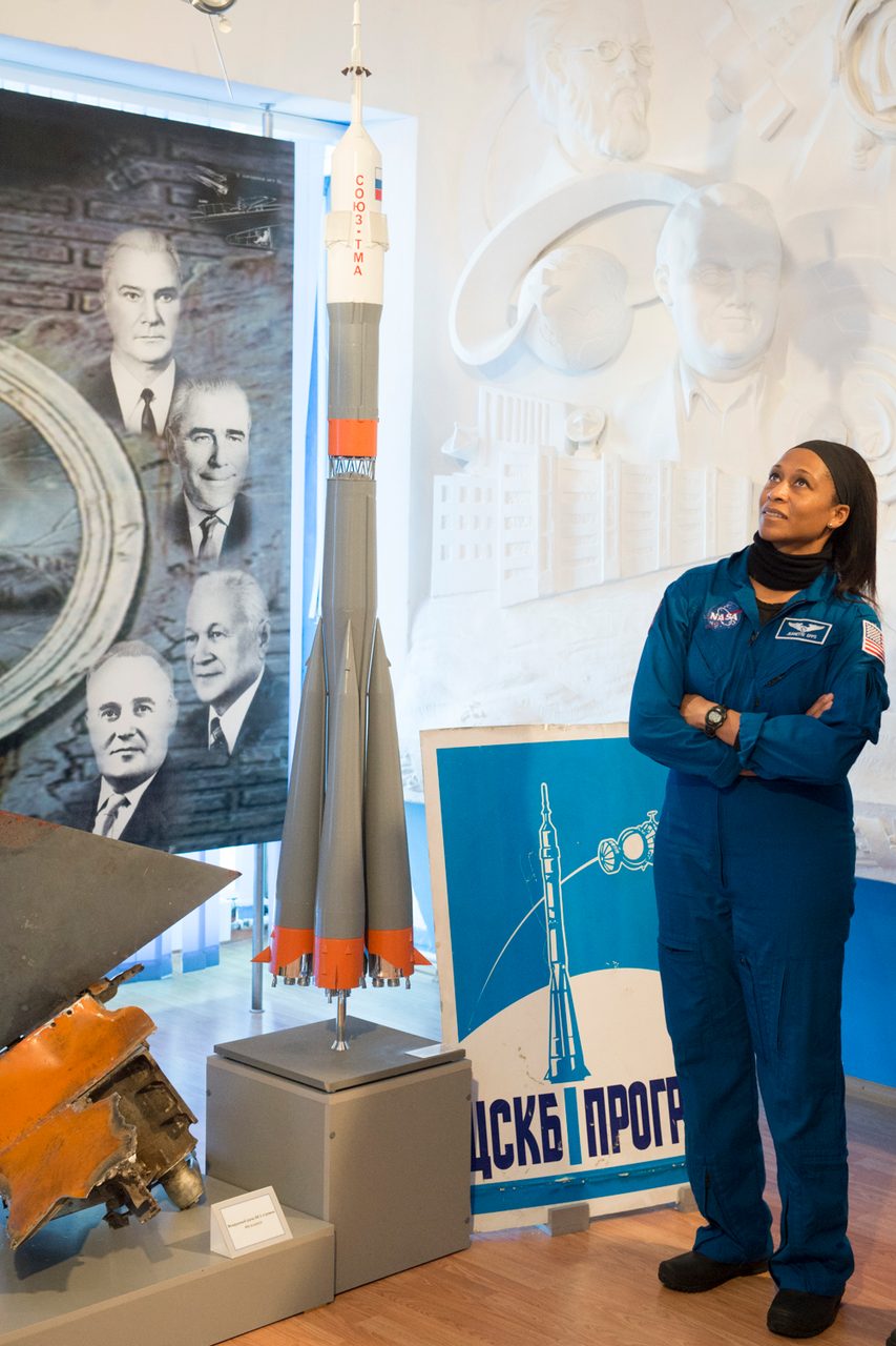 NASA astronaut Jeanette Epps examines a Soyuz rocket model at the Baikonur Museum during pre-launch activities.