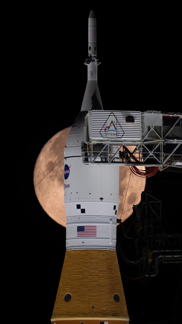 Full moon setting behind NASA's SLS and Orion spacecraft at Launch Pad 39B, early morning February 1, 2026.