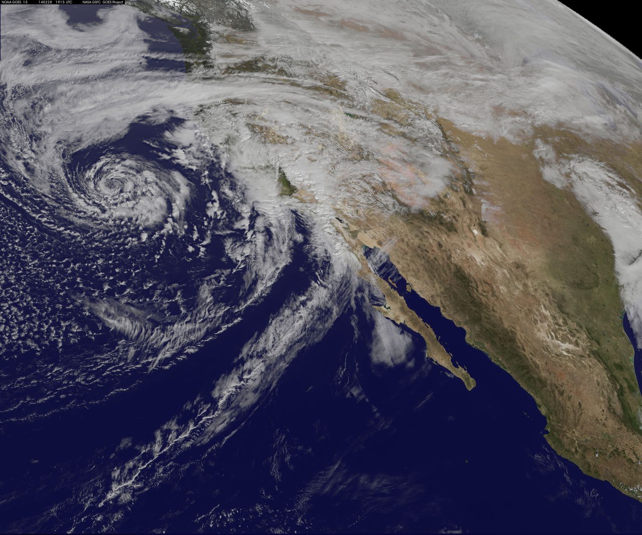 Satellite imagery showing a large storm system approaching the California coastline with dense cloud cover.