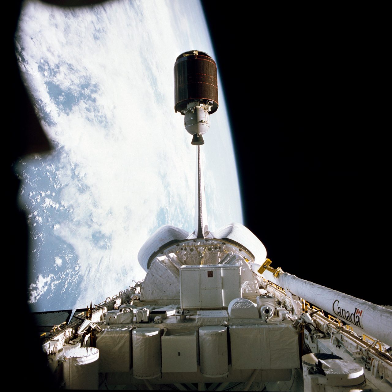 Palapa-B satellite being deployed from Shuttle Challenger against Earth's backdrop.