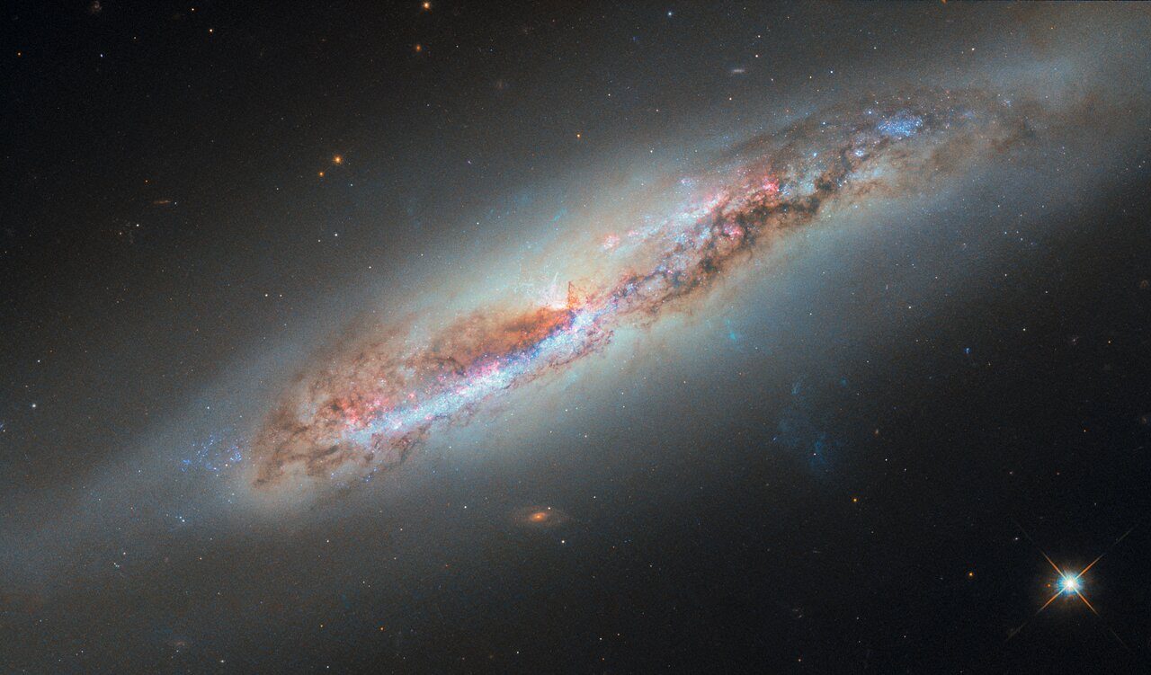 A vibrant cosmic scene showing colorful galactic gas clouds dispersing into space.