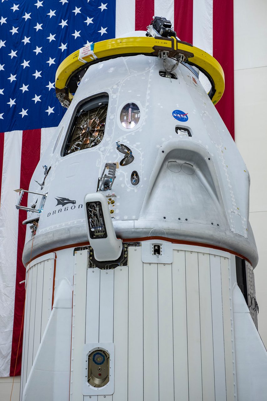 SpaceX Demo-2 Crew Dragon spacecraft and trunk stacked in a hangar, ready for launch.