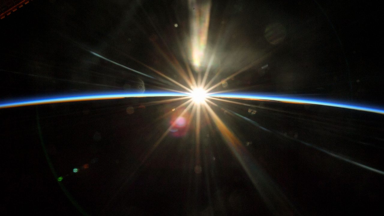 Astronaut conducting maintenance outside the International Space Station with Earth visible in the background.