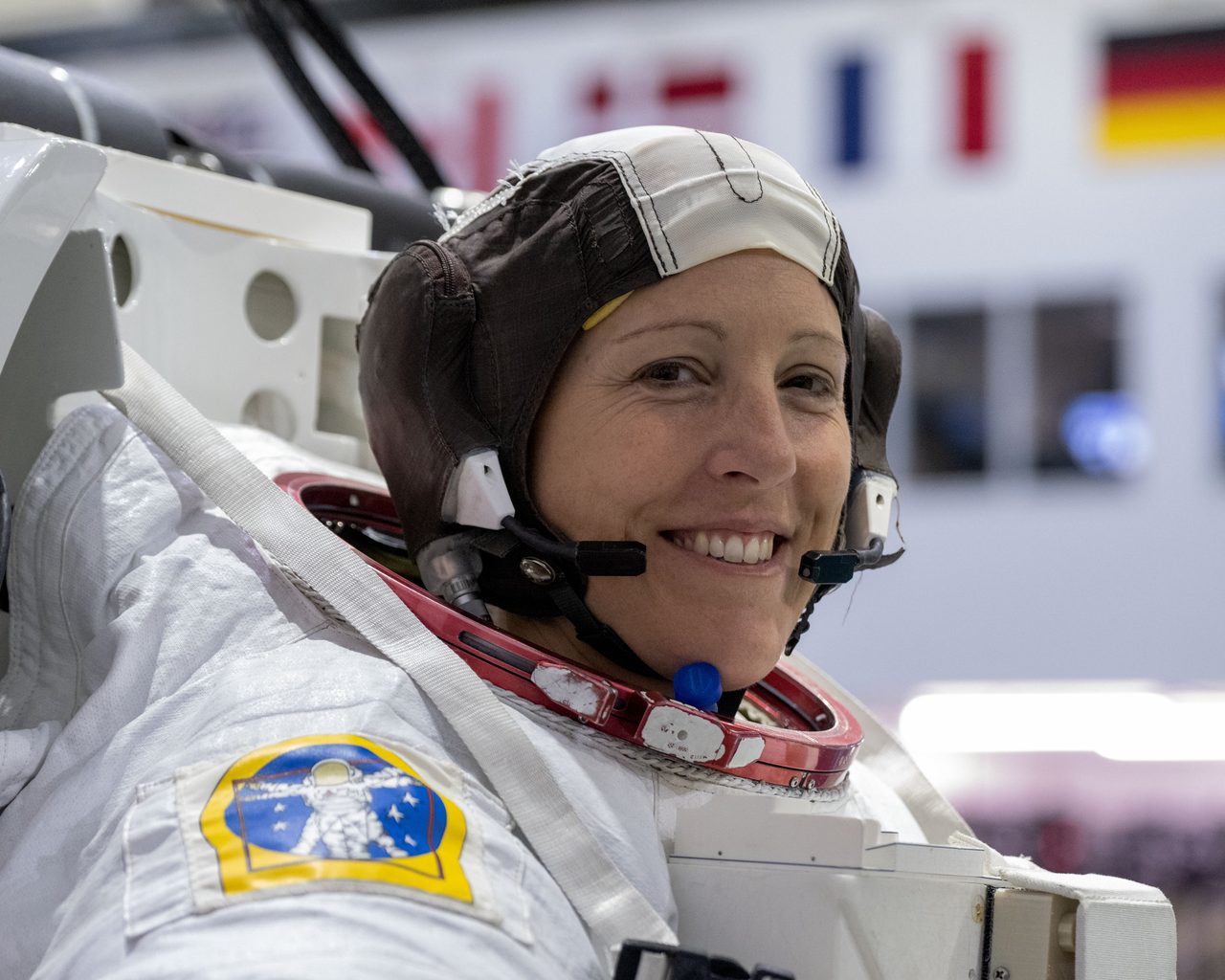 ESA astronaut Sophie Adenot in spacewalk gear, smiling during training at Johnson Space Center's Neutral Buoyancy Laboratory.