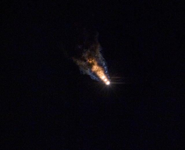 The Parker Solar Probe launches into space, leaving a trail of smoke against a clear blue sky.