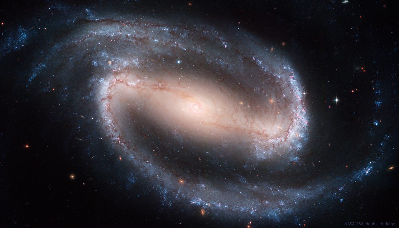 A detailed view of NGC 1300, a barred spiral galaxy with bright core and sweeping spiral arms in deep space.