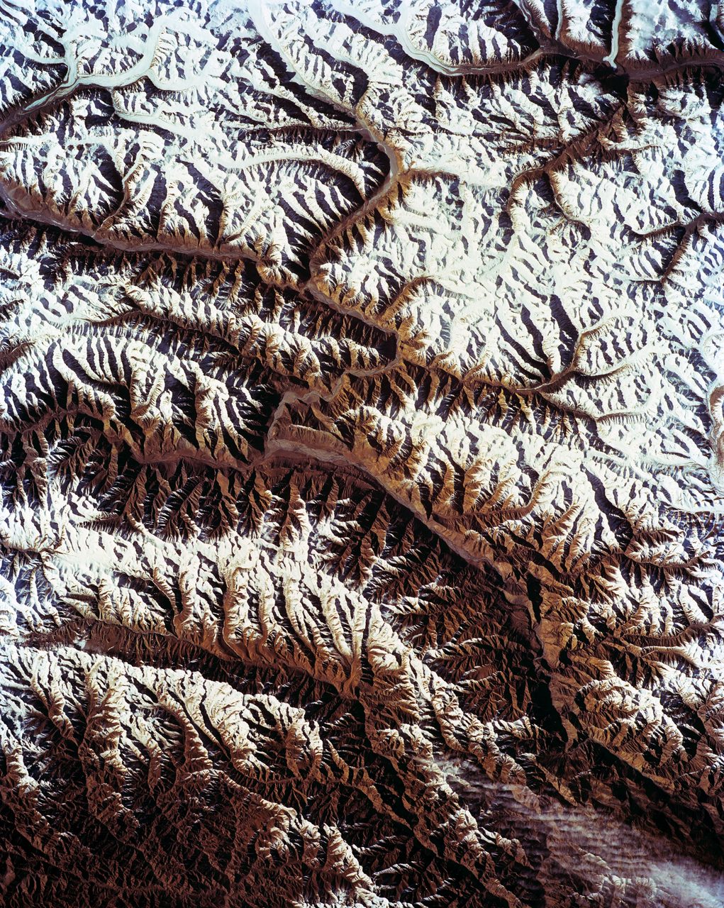 Aerial view of the Karakorum Range in northern India with snow-capped peaks and rugged terrain.