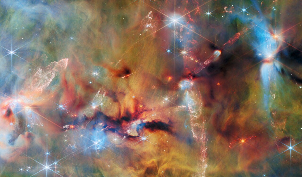 A vivid cosmic scene showing young stars at various formation stages, captured by the Webb telescope.