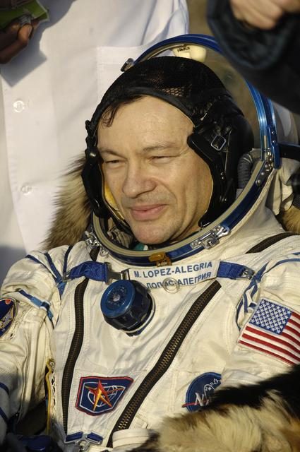 Expedition 14 crew safely lands in a barren landscape, parachutes visible above the spacecraft.