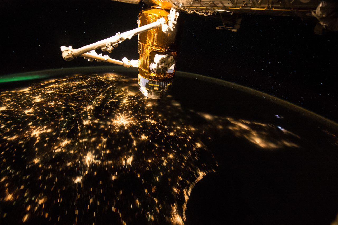 View of Earth from the International Space Station showing land, ocean, and cloud formations.