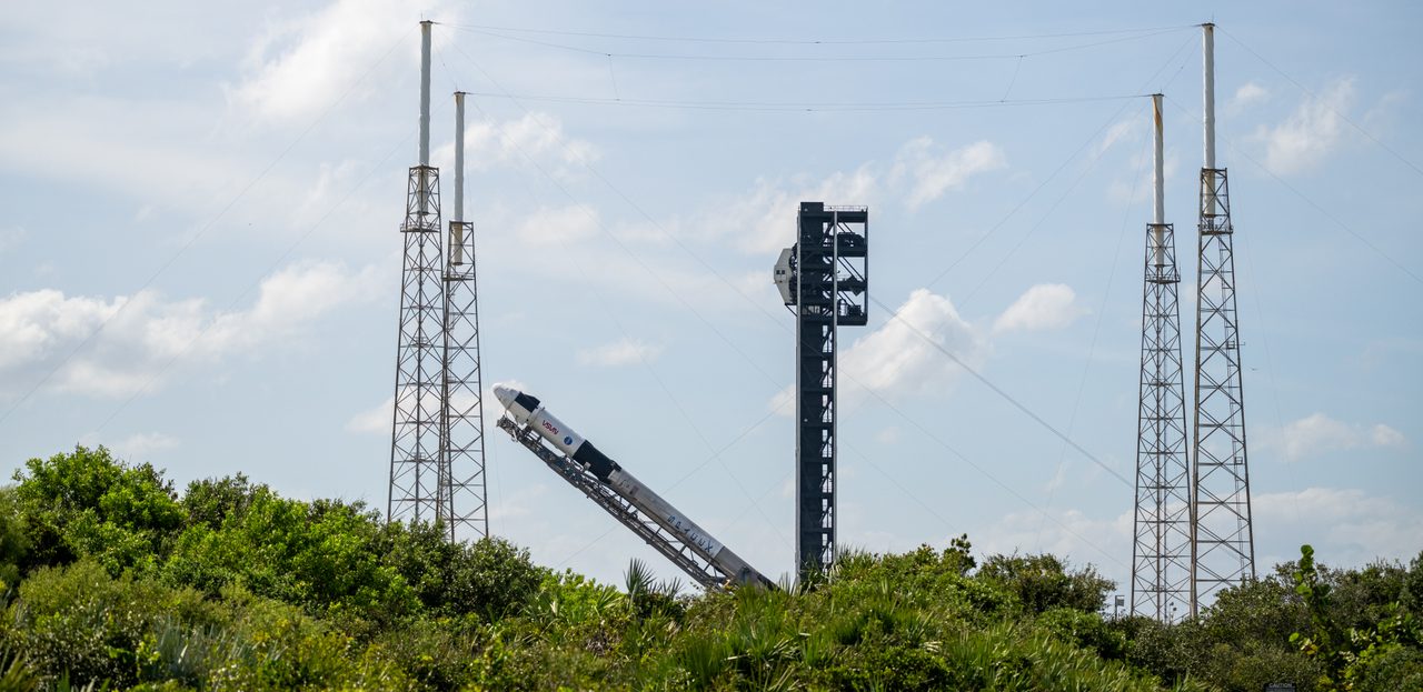 SpaceX Crew-9 Falcon 9 rocket and Dragon capsule on launch pad at sunrise.