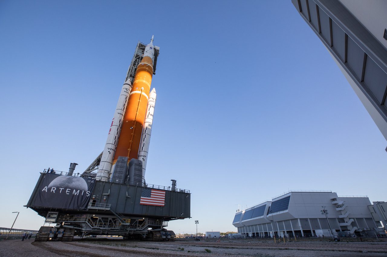 Artemis I rocket being transported on a crawler-transporter during nighttime rollout at Kennedy Space Center.