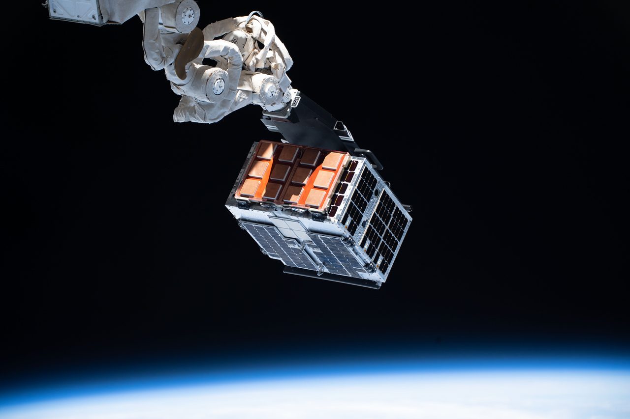 View of the International Space Station orbiting Earth with solar panels and modules visible.