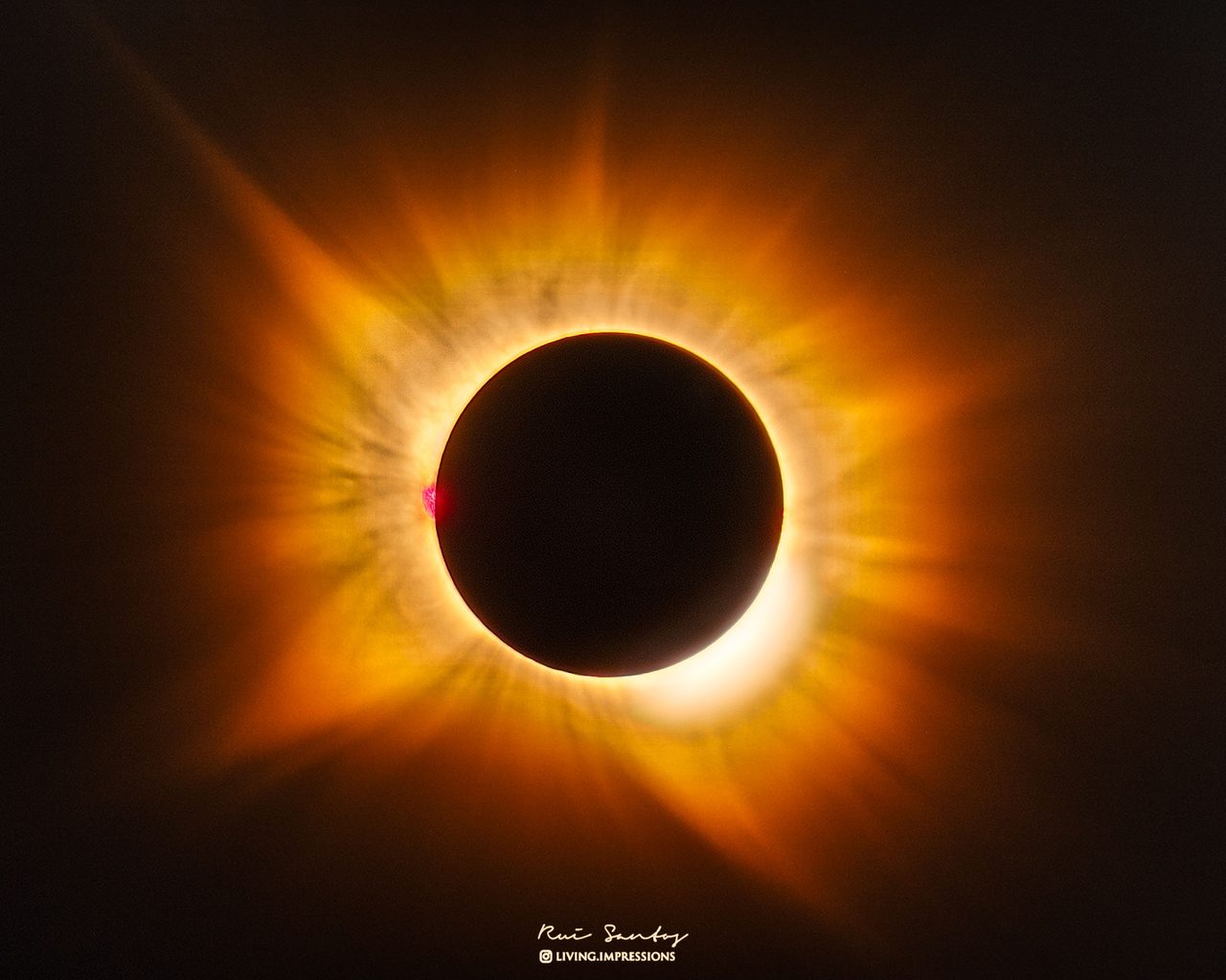 A solar eclipse with a golden corona visible against a dark sky, creating a dramatic celestial scene.