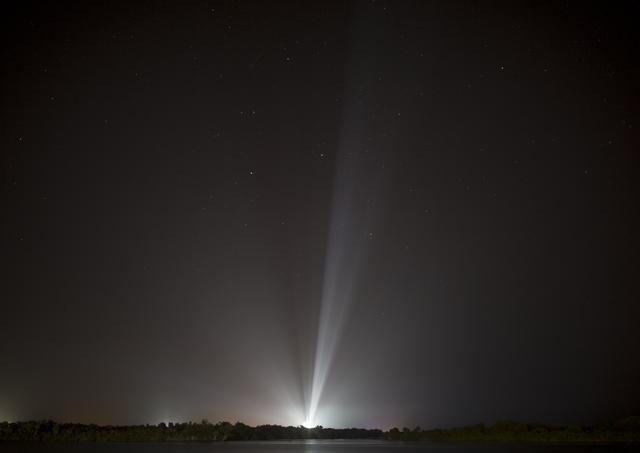SpaceX Falcon Heavy rocket launching at night with bright flames against a starry sky