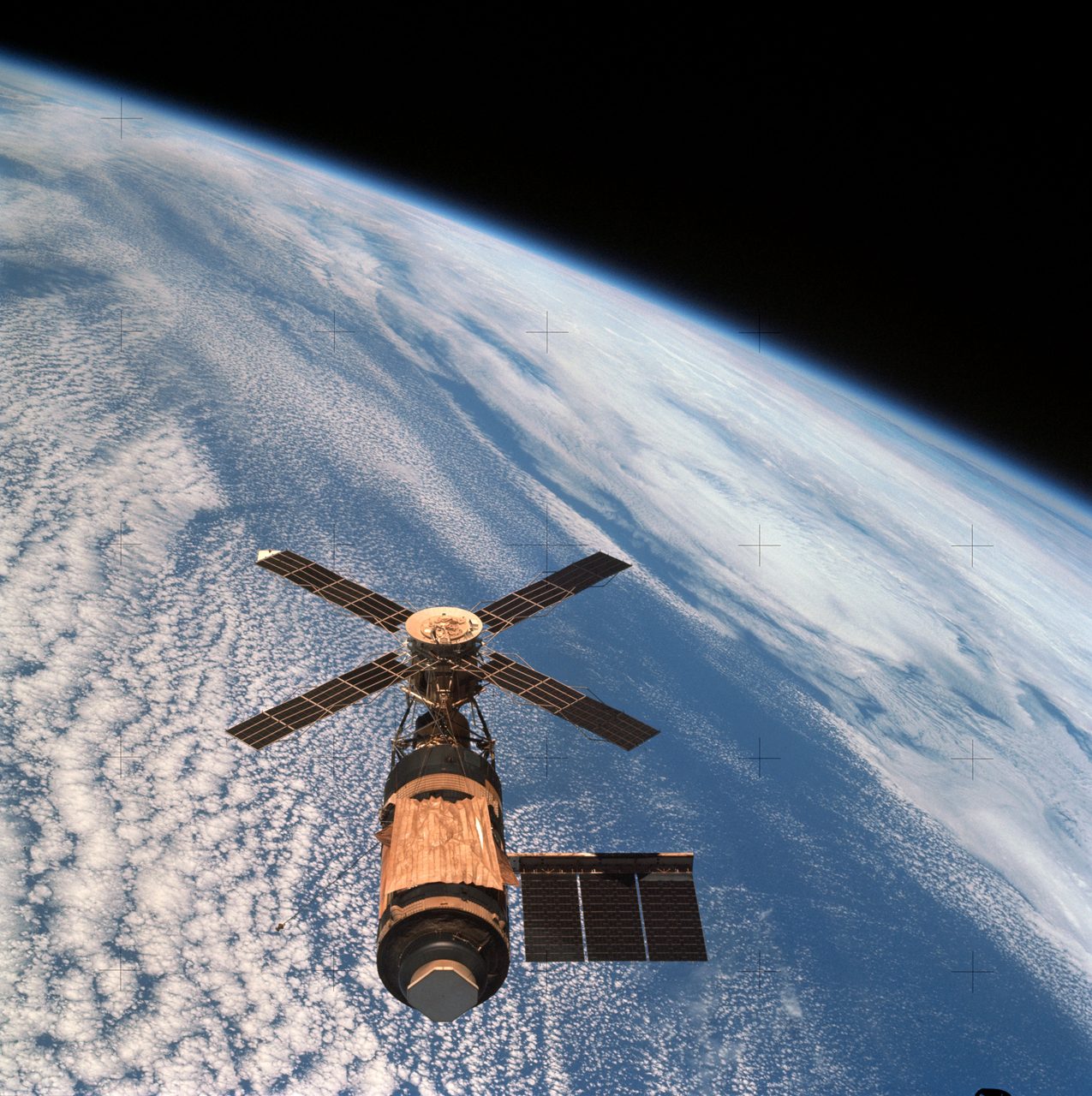 Skylab space station cluster orbiting Earth, viewed from the Command and Service Module.