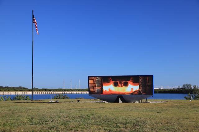 A cozy fireplace setup near NASA's iconic countdown clock, creating a warm atmosphere.