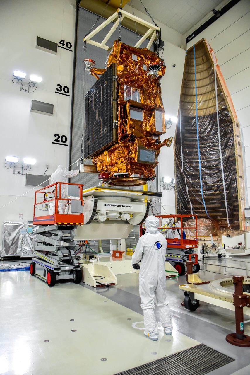 Technicians carefully move the JPSS-2 spacecraft onto an integration and testing cart at the facility.