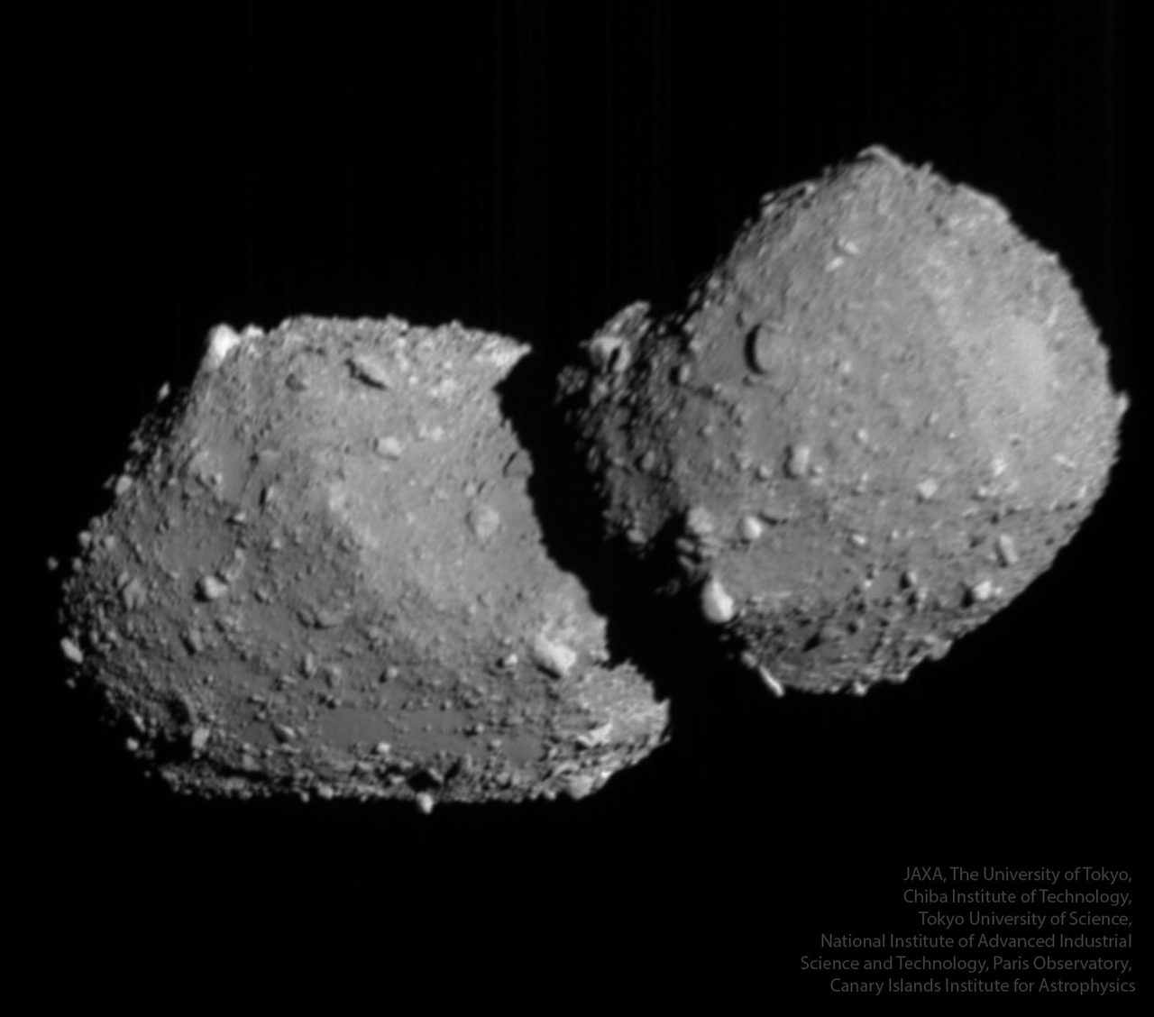 A detailed view of the double-lobed asteroid Torifune floating in the dark expanse of space.