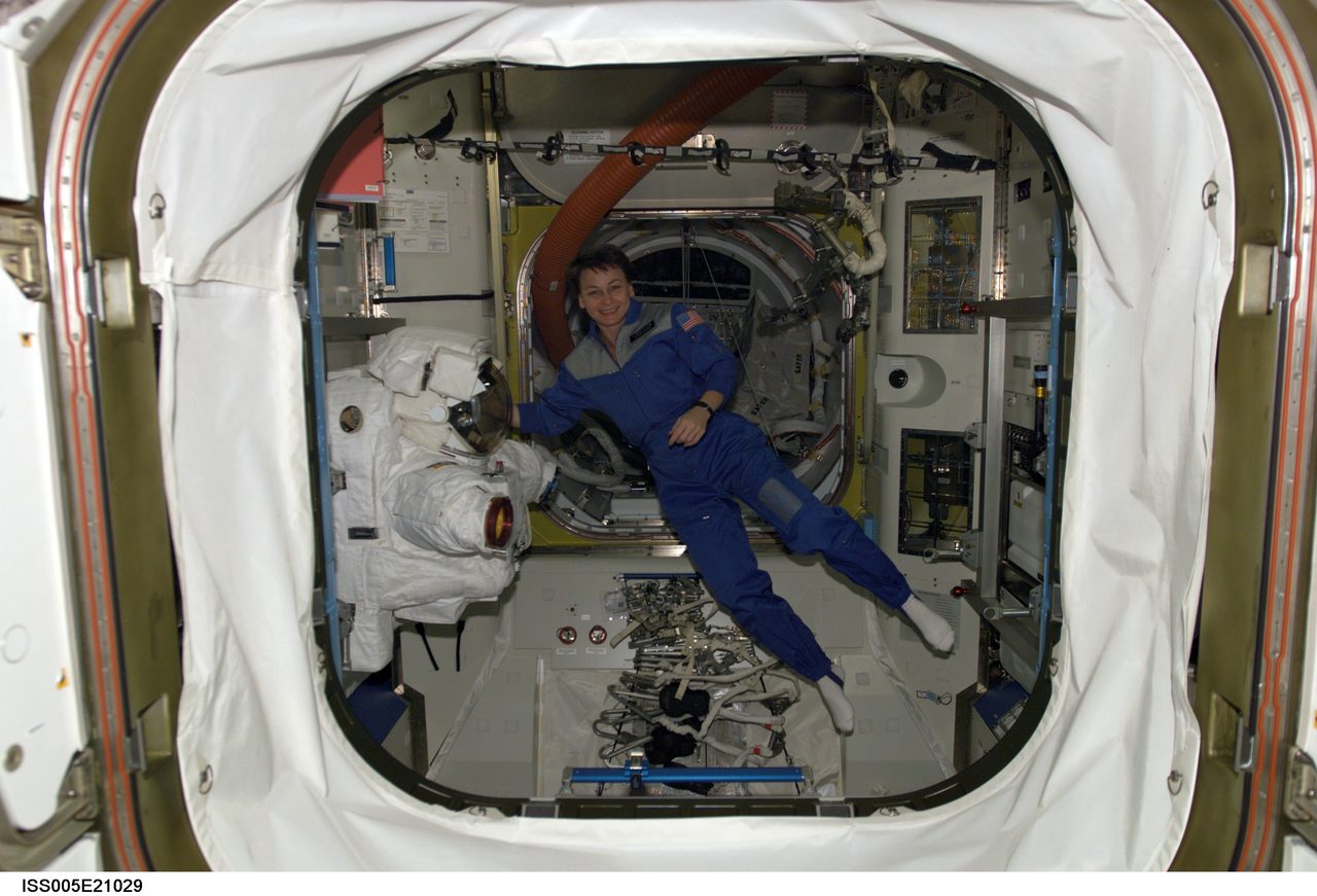 Astronaut Peggy Whitson floats in the Quest airlock on the International Space Station during Expedition Five.