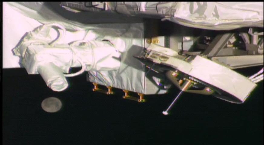 Earth's moon passing below NASA OPALS laser instrument on International Space Station, captured by robotic camera