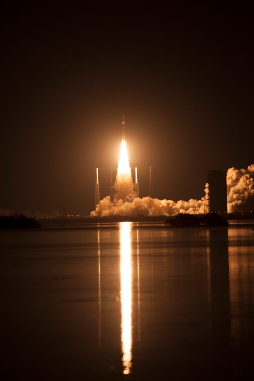 GOES-R satellite launching into space with fiery trail against night sky