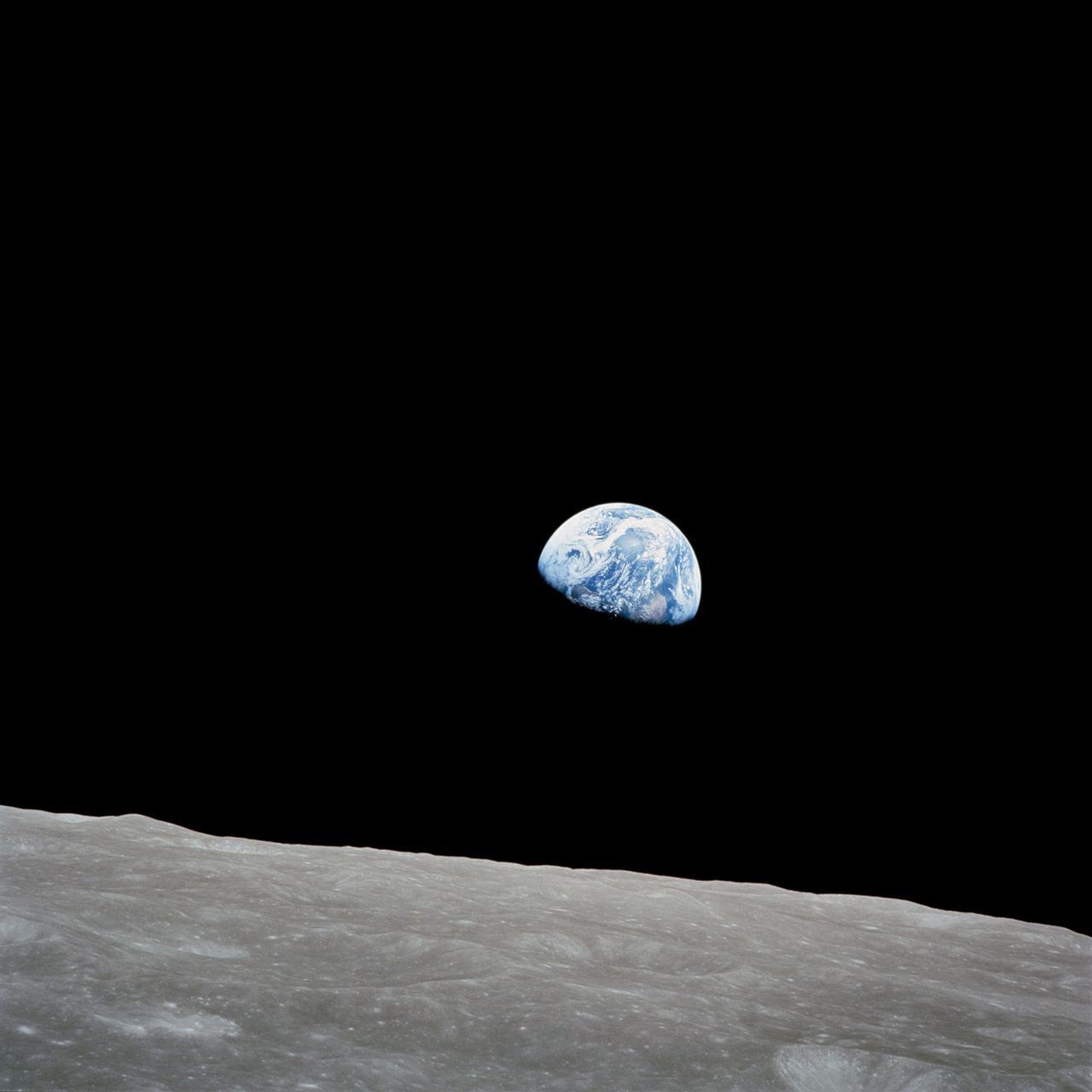 Earth rising over the moon's horizon during Apollo 8 mission, showcasing space exploration's beauty.