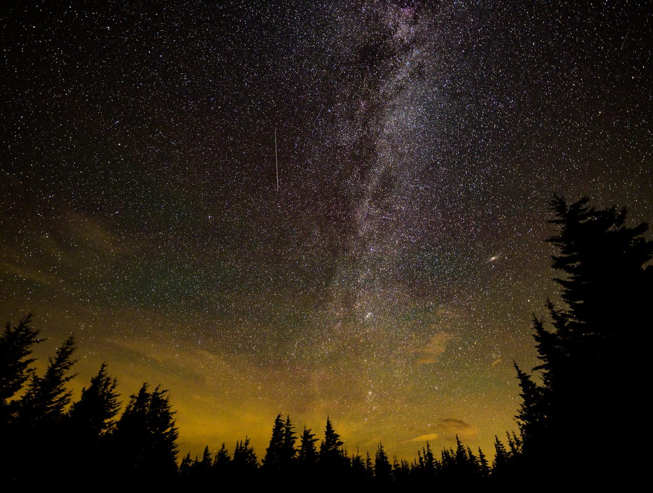 Bright streaks of Perseid meteors illuminate the night sky during annual meteor shower event.