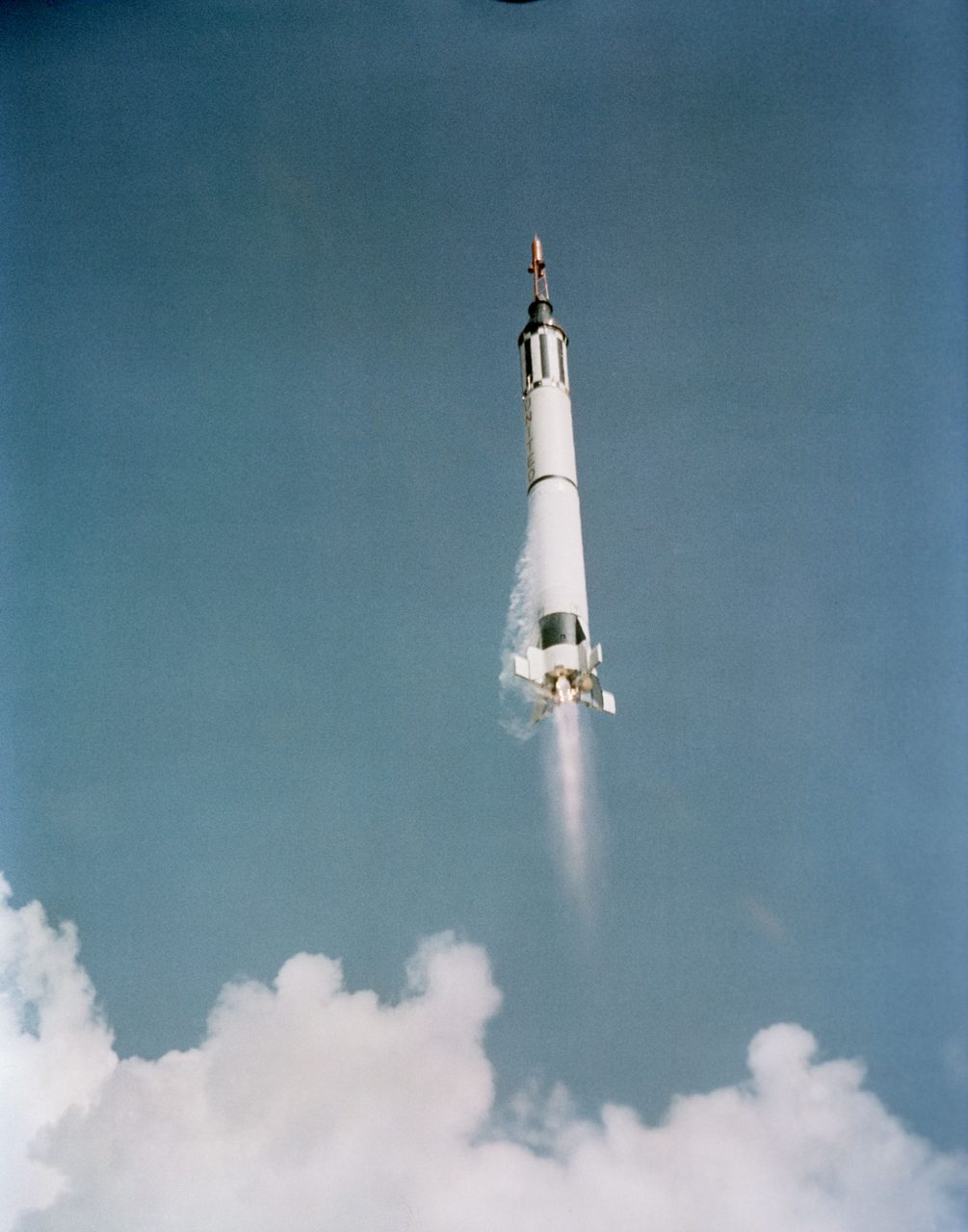 Rocket launching from Cape Canaveral, leaving a trail of smoke against a bright sky.