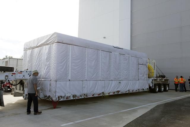 GOES-S satellite being transported on a large truck to Astrotech Space Operations facility.