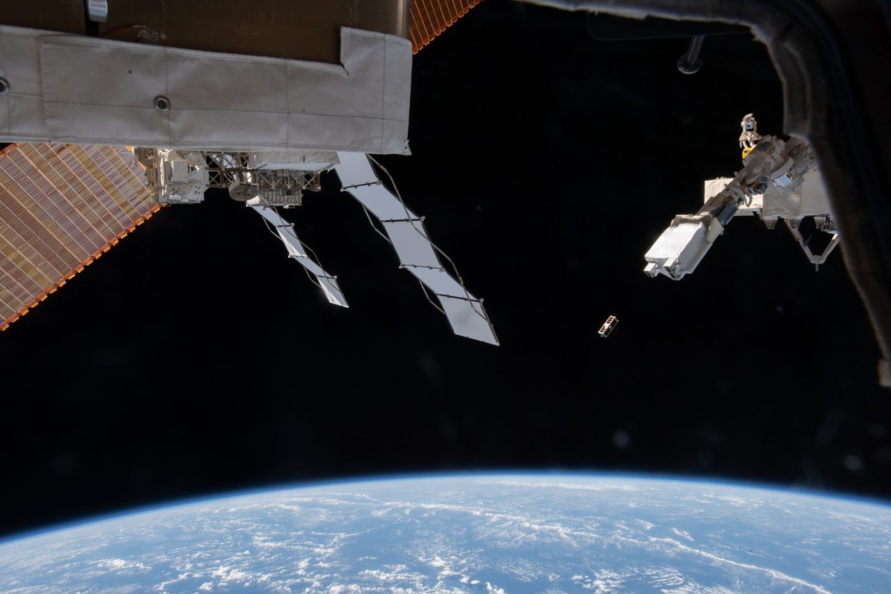 Aerial view of Earth from space with swirling clouds and ocean visible.