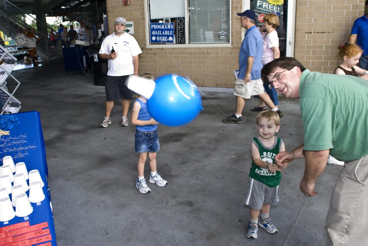 Crowd gathered at Zephyr Field for NASA Night event hosted by Stennis, featuring educational activities and exhibits.
