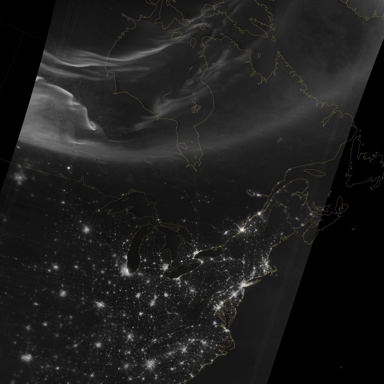 Vibrant aurora borealis illuminating the night sky over North America, with swirling green and purple hues.