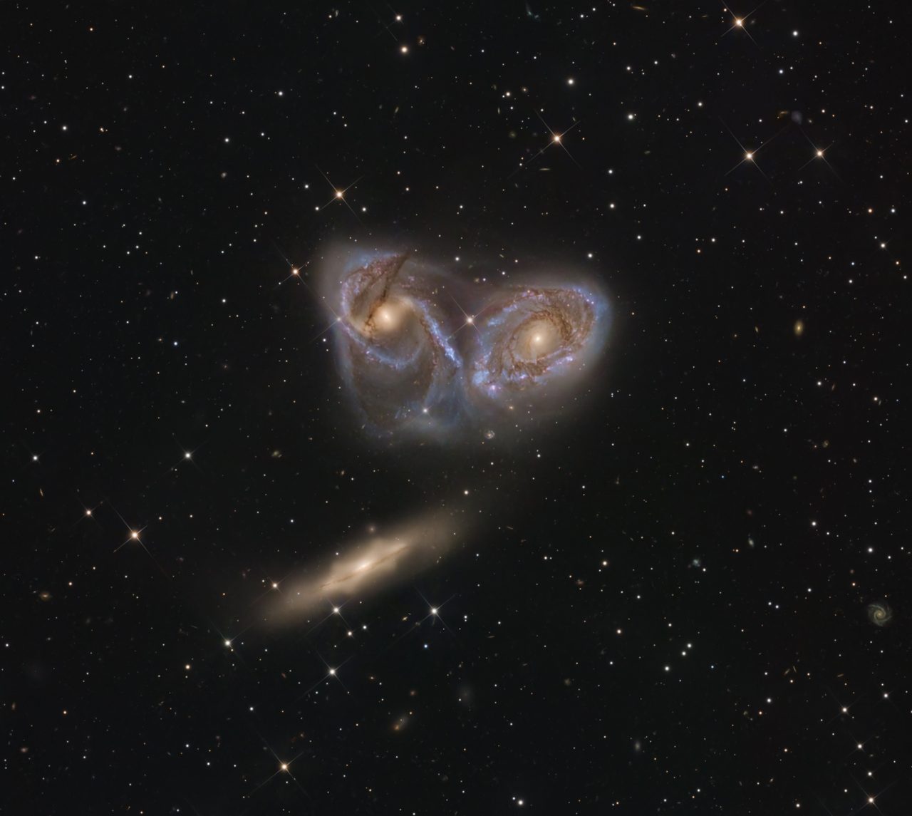 A stunning view of three distinct galaxies in the Pavo constellation, showcasing their unique shapes and colors.