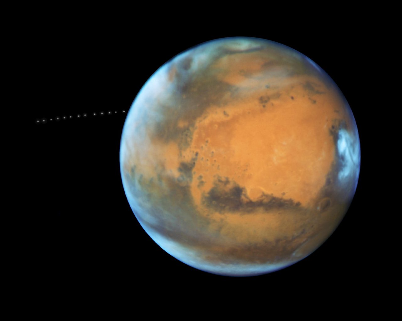 Hubble Space Telescope captures Mars' moon Phobos in orbit, showcasing its small size against the vastness of space.