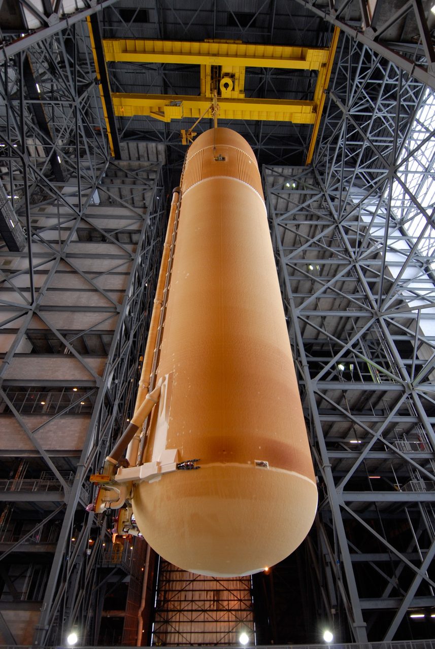 Space shuttle Atlantis on launch pad at Kennedy Space Center under clear blue sky.