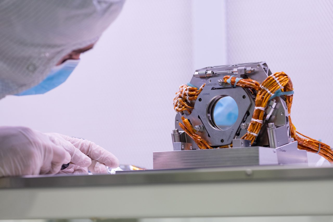 Engineer inspects fast steering mirror on Coronagraph Instrument, crucial for stabilizing Roman spacecraft's optical bench.