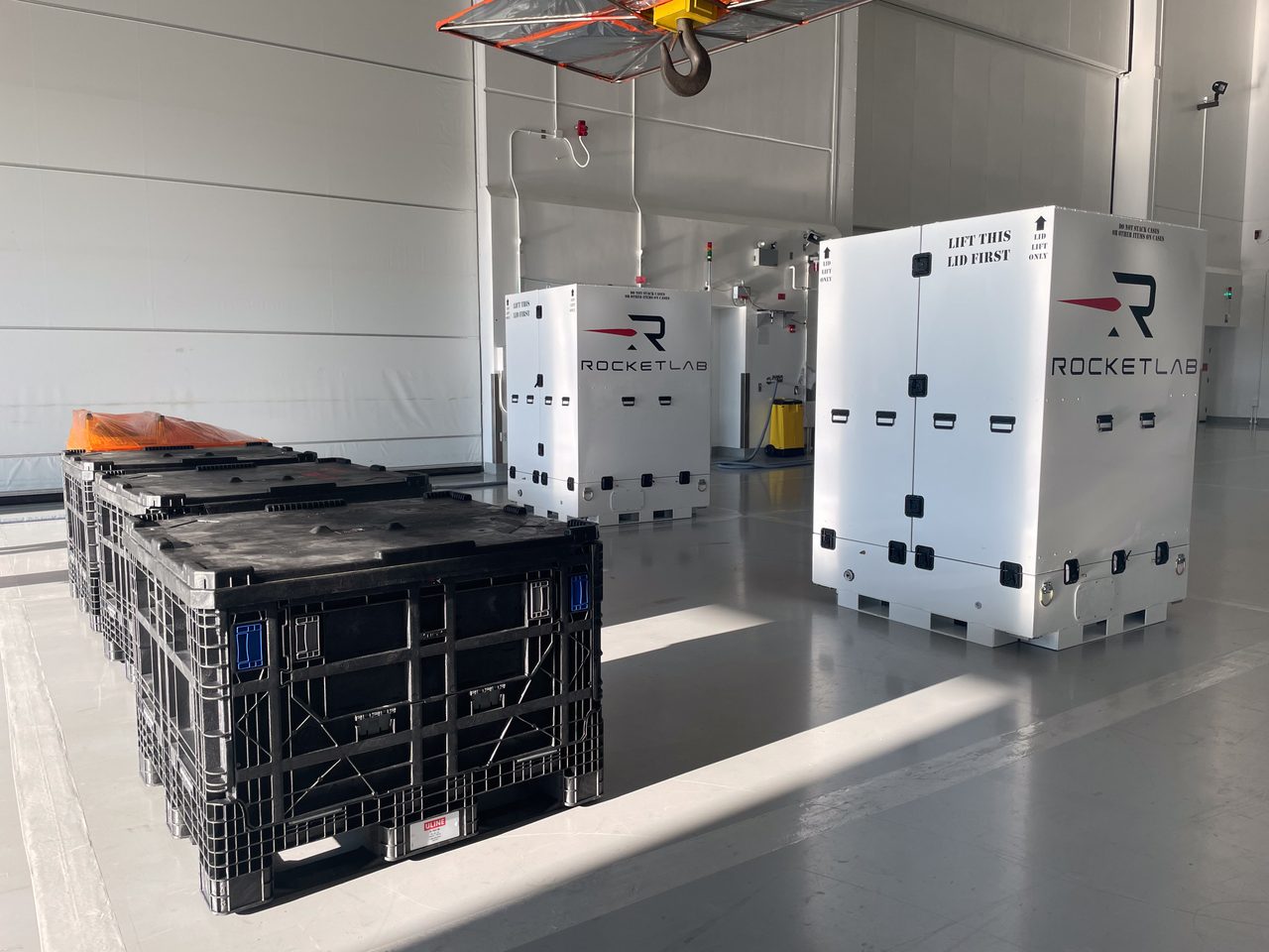 Technicians carefully unloading ESCAPADE spacecraft components from a transport container.