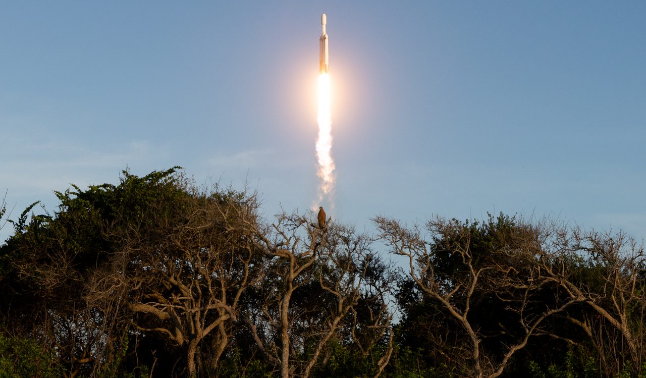 Illustration of Nancy Grace Roman Space Telescope launching into space with vibrant starry background.
