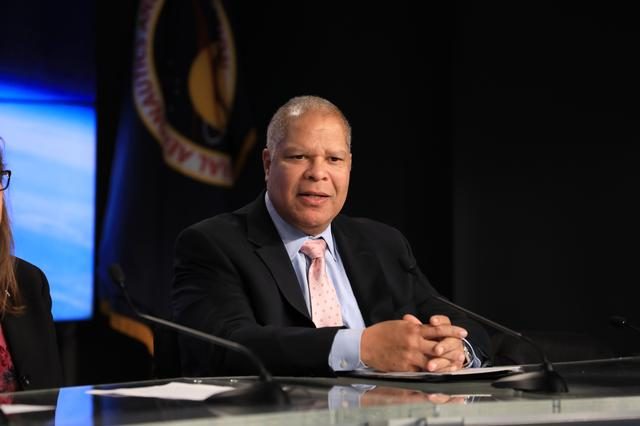 Scientists present findings at the GOES-R satellite science briefing in a conference room.