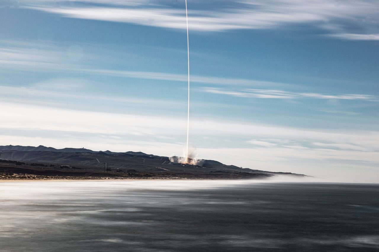 Rocket launching Sentinel-6 satellite into space against a clear sky.