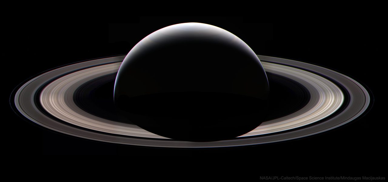 A stunning view of Saturn with its rings illuminated against a dark night sky, showcasing its majestic beauty.